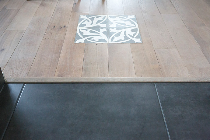 Installation d’une barre de seuil entre les deux revêtements (parquet massif et carrelage)